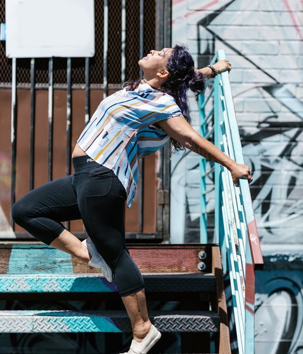 Energetic woman stretching outdoors, feeling vibrant and full of life.